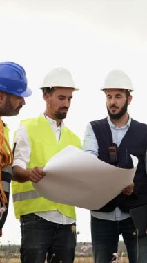 Mühendisler ve teknik işçiler açık havada çalışıyorlar. Planlanan proje planı ile yenilenebilir enerji geliştirme.