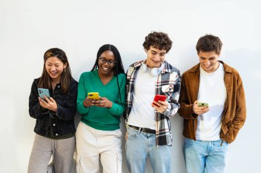 Sosyal medyadaki içeriği paylaşmak için cep telefonu uygulamasını kullanan genç arkadaşlar eğleniyor