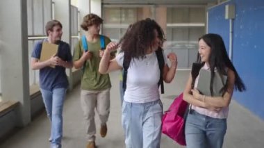 Asyalı ve Afrikalı Amerikalı kız arkadaşlar koleje gidiyorlar - Neşeli ortaokul öğrencileri sınıflarına geri dönüyorlar 