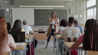 Üniversite öğretmeni, üniversite giriş sınavına hazırlanan lise öğrencilerine fen sınavı veriyor. 