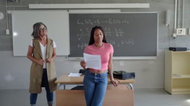Lisedeki sınıf arkadaşlarına ve öğretmenlerine okuma projesi sunan Afrikalı Amerikalı kız öğrenci.