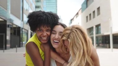 Yazın şehirde eğlenen üç genç bayan arkadaş, birbirlerine bağlanıyorlar ve sevgiyle sarılıyorlar. 