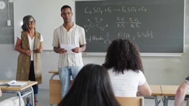 Afrikalı Amerikalı öğrenci üniversitede sınıf arkadaşlarına ve öğretmenlerine akademik sunum yapıyor.