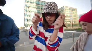 Güçlü bir kadın kentteki bir grup arkadaşla birlikte modern sokak dansı yapıyor.