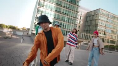 Şehirdeki bir grup arkadaşıyla birlikte modern şehir sokak dansı yapan Asyalı bir adam.