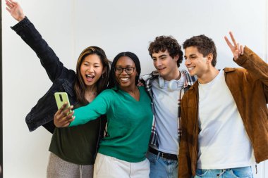 Bir grup arkadaş cep telefonu uygulaması kullanarak selfie çekiyorlar, takılıyorlar ve eğleniyorlar.