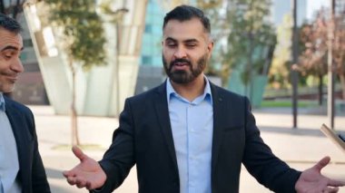 Hintli iş adamı şirket toplantısında meslektaşları ve çalışanlarıyla konuşuyor. 