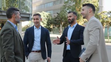 Dört profesyonel İspanyol ve Ortadoğulu işadamı finans şehrinde açık havada konuşuyor.