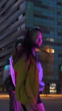 Asyalı Çinli kız, şehirdeki müzik sokak partisinde arkadaşlarıyla dans ederken eğleniyor.