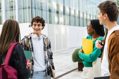 Öğrenci arkadaşlar okuldan sonra kampüste konuşuyorlar. Küresel eğitimde çeşitlilik 
