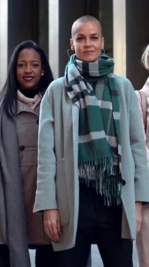 Şirketin dışında gülümseyen zarif iş kadınlarından oluşan mutlu bir ekip.