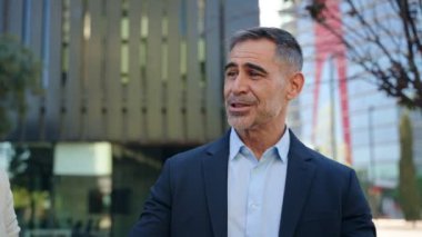 Uluslararası iş adamlarından oluşan bir grup açık havada iletişim kuruyor, şehirde şirket stratejisini konuşuyor ve tartışıyorlar. 