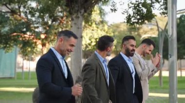 Şehirdeki dört işadamı, anlaşma sağlandıktan sonra tatmin olmuş bir şekilde yürüyüp konuşuyorlar. 