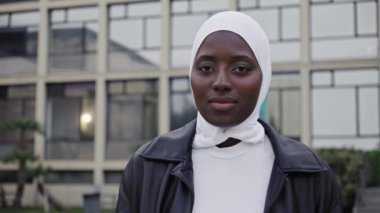 Müslüman başörtüsü takmış, gülümseyen kameraya bakan Afrikalı kız öğrencinin portresi