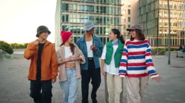 Bir grup modaya uygun Z nesli genç arkadaş şehirde birlikte yürüyüp sohbet ediyorlar. Kentsel Çeşitlilik
