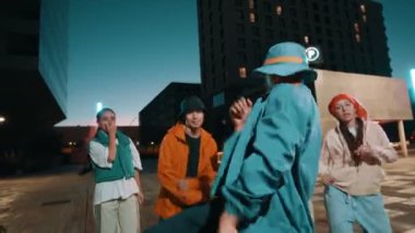 Afro-Amerikalı bir grup genç trend arkadaşıyla gece şehirde dans ediyor.