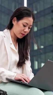 Ofis dışında dizüstü bilgisayarla çalışan genç Asyalı Profesyonel Kadın - Kadın ilham ve hırsı