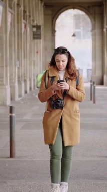 Genç turist kadın cep telefonu GPS navigasyon uygulamasını kontrol ediyor, tarihi kenti keşfediyor ve ziyaret ediyor 