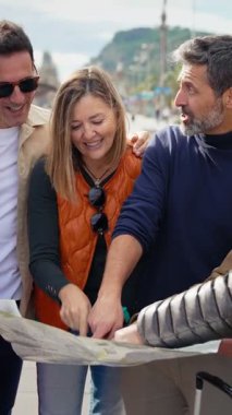 Şehir haritasında otelin dönüm noktasını arayan bir grup mutlu turist