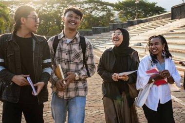 Mutlu Asya Üniversitesi öğrenci arkadaşları dersten sonra dışarıda gülüyor. Endonezya Eğitimi