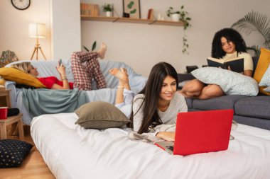 Ev arkadaşı kızlar ders çalışıyor ve hafta sonları pijamalarıyla yatakta dinleniyorlar.