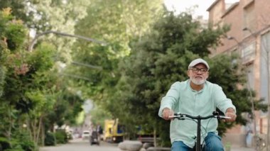 Şehir parkında bisiklet süren rahat bir son sınıf öğrencisi. sağlıklı yaşam tarzı