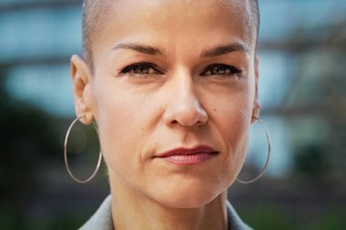 Kısa saçlı, özgüvenli bir kadının portresi, azimle kameraya bakıyor.