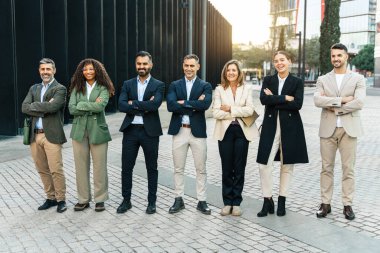Kendine güvenen iş adamları modern ofis binalarının dışında takım çalışması ve başarı göstererek bir arada duruyorlar.