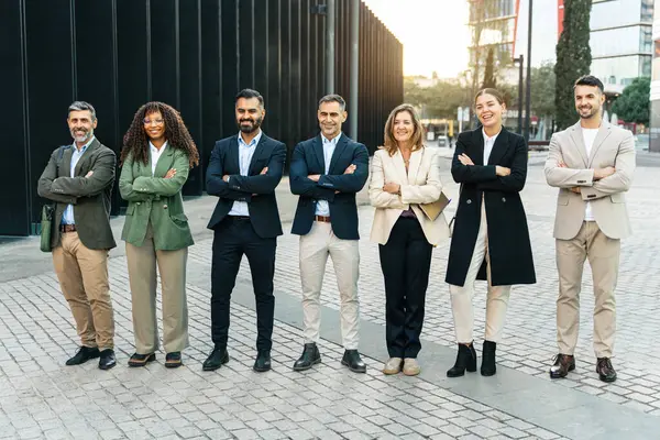 Kendine güvenen iş adamları modern ofis binalarının dışında takım çalışması ve başarı göstererek bir arada duruyorlar.