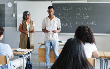 Afrikalı Amerikalı öğrenci üniversitede sınıf arkadaşlarına ve öğretmenlerine akademik bilim sunumu yapıyor.