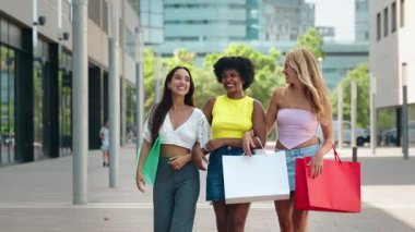 Kasabada alışveriş torbalarıyla gezen üç neşeli genç kadın - gülen arkadaşlar 