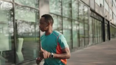 Afrikalı Amerikalı adam şehirde koşuyor.