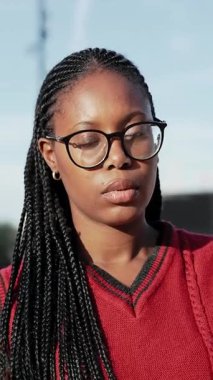 Uzun örgülü ve gözlüklü siyah bir kadının portresi. Afrikalı Amerikan Koleji öğrencisi