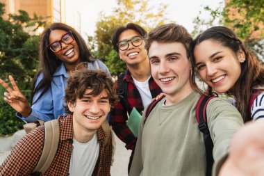 Şehir parkında cep telefonuyla selfie çeken genç arkadaşlar. Öğrenciler Kendi Portresi 