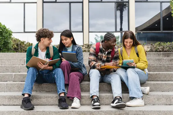 Üniversite sınavlarına hazırlanan bir grup üniversite öğrencisi merdivenlerde oturmuş birlikte öğreniyorlar. 