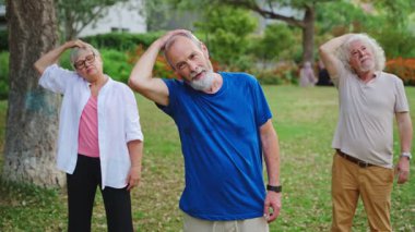 Olgun insanlar şehir parkında egzersiz yapıyor. Yaşlılar için sağlıklı bir yaşam tarzı.