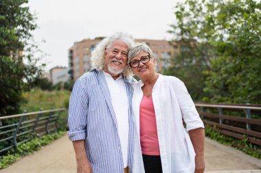 Şehir parkında aşkla kaynaşan yaşlı çiftin romantik portresi. 