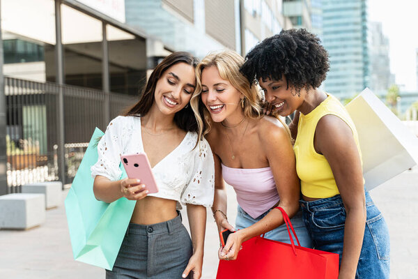 Group of girl friends looking videos online on social media in their smartphone