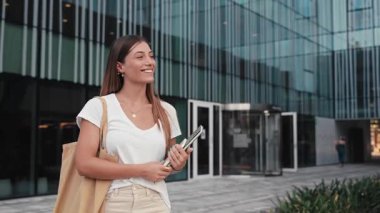 Ekonomi ve İşletme Fakültesi binasının önünde yürüyen üniversite öğrencisi bir kadın.