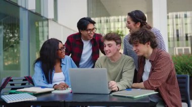 Sınavlara hazırlanan ve kampüs kütüphanesinde üniversite projesi üzerinde çalışan bir grup öğrenci.