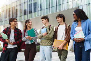 Üniversite öğrencileri üniversite merdivenlerinde yürüyor. Ders ve sınavlardan sonra konuşup gülüyorlar.
