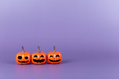 Pumpkin made from plastic with smile face emotico on purple background. Halloween and decoration concept. Front view and copy space