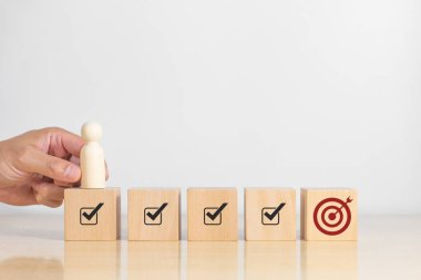 Hedef tahtası ve okları hedefe doğrultulmuş oklar taşıyan bir tahta adam. İş başarısı artışı kavramı