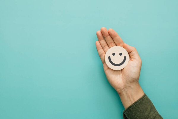 Service rating, satisfaction and positive feedback concept. Customer show smile face emoticon for a five-star rating