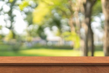 Bulanık doğa Bokeh Green Park arka planında tahta masa. Reklam ürünleri veya ürünleri için kullanılan boş tahta masa üstü