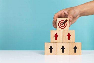 Ticari başarı artışı kavramı, müşteri hedef kitlesi ve planlama gelişimi. Tahta bloğu ikon hedefli ve başarılı olmak için ok atan bir adam.