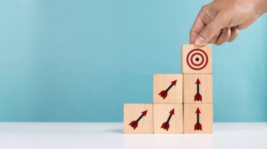 Hedef hedef, ticari başarı artışı pasif gelir pazarlaması, kâr planlama. Simge hedefli ahşap küp ve hedefi gösteren oklar.