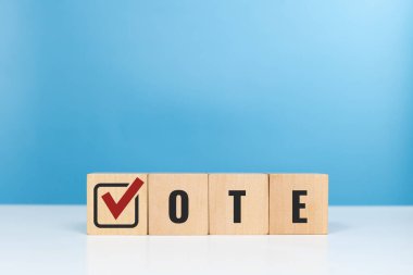 VOTE, seçim, anket ve oy kullanma sembolleri kavramı. Ofisteki masada işaretli sembollü tahta küplere oy verin.