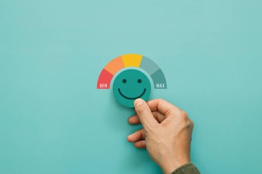 Hizmet derecesi, memnuniyet ve olumlu geri bildirim. Gülümseyen yüz ifadesini seçen bir adam beş yıldızlı bir not verir. Bu da servisten en yüksek tatmin seviyesini gösterir.