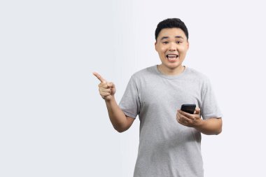 Gülümseme portresi mutlu adam elinde akıllı telefonu tutarken vücudunun önünde fotokopi aletiyle işaret ediyor.